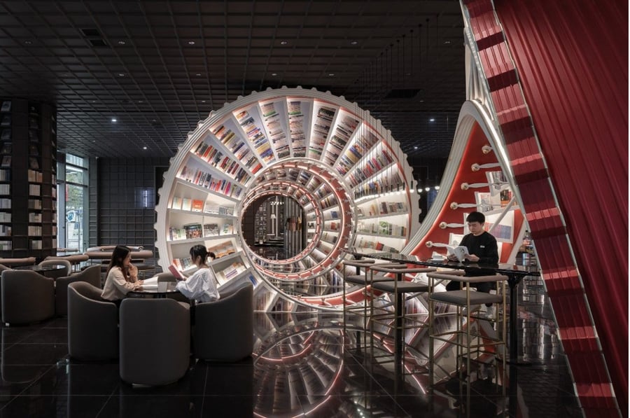 Patrons mingle and work in the spacious reading room in front of the Shenzhen Zhongshuge bookstore's central spiraling bookcase. 