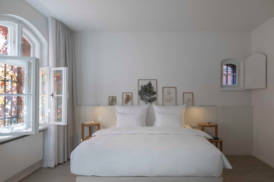 Minimalist guest bedroom in the Wilmina hotel exudes calm, minimalist vibes and lets in lots of natural light. 