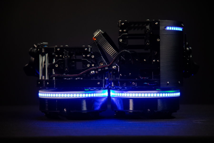 Side view of the Ekto One VR Boots, with the LEDs along the bottom of the shoe glowing a brilliant blue.