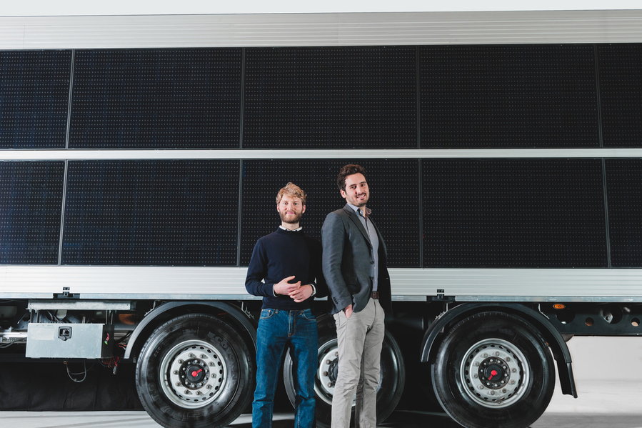 The Sono Motors founders stand in front of the large solar EV tractor-trailer they showcased at CES 2021.