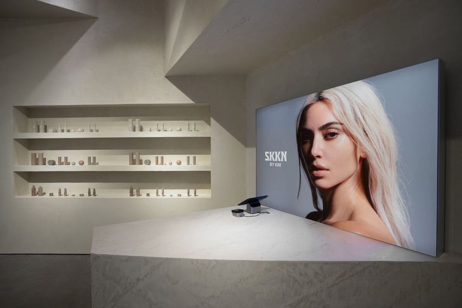 Digital display inside the SKKN pop-up store showcases a large photo of Kim Kardashian's face. 