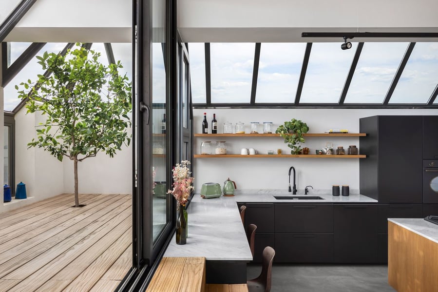 La Serenissima's sleek kitchen space is located right next to the home's transitional wooden deck space.