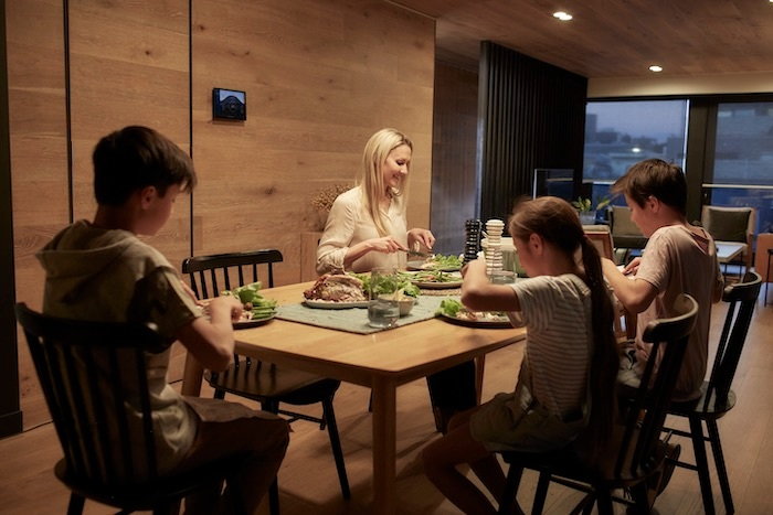 A family enjoys a home-cooked dinner surrounded by clean air and abundant natural light.