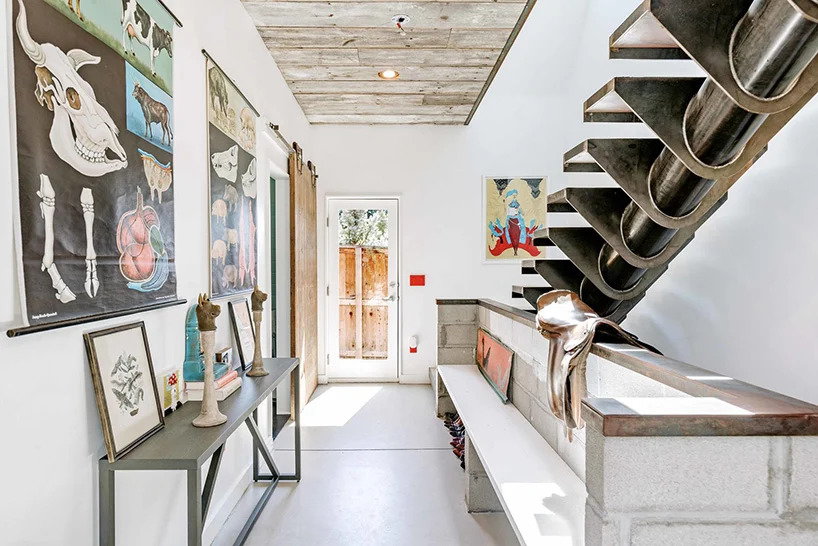 The shipping container home's main entry/stairway is simple, rustic, and decidedly refined.