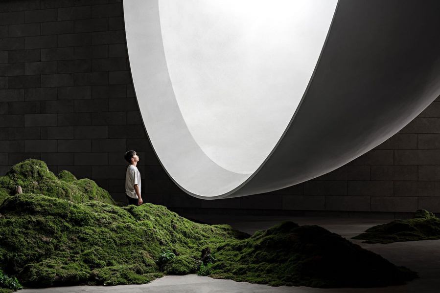 Man looks into the shimmering celestial sphere inside the new Hometown Moon Chapel. 