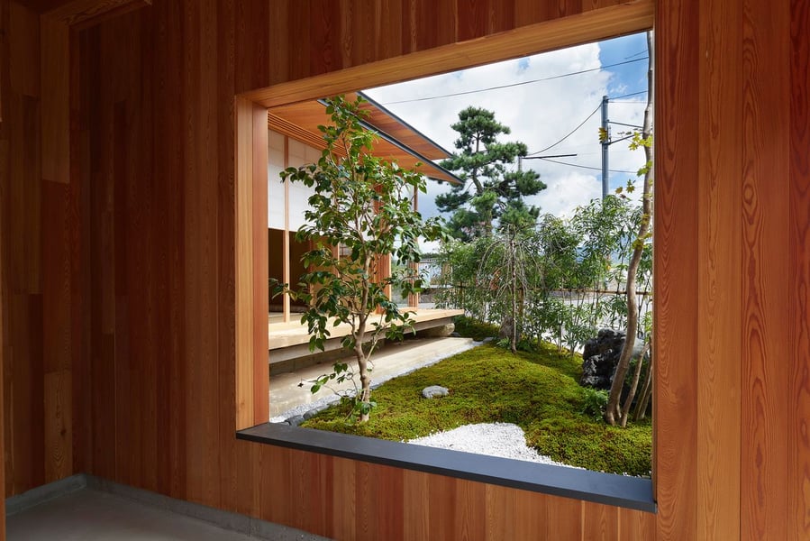 View of the lush garden area outside the House in Shimogamo through a large opening in an interior wall.
