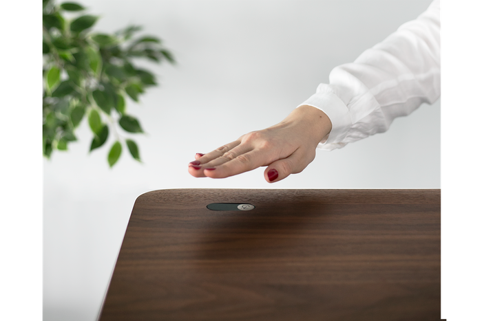 A small sensor built into the Magic Desk allows to you lower or raise the whole thing with a simple wave of  your hand. 