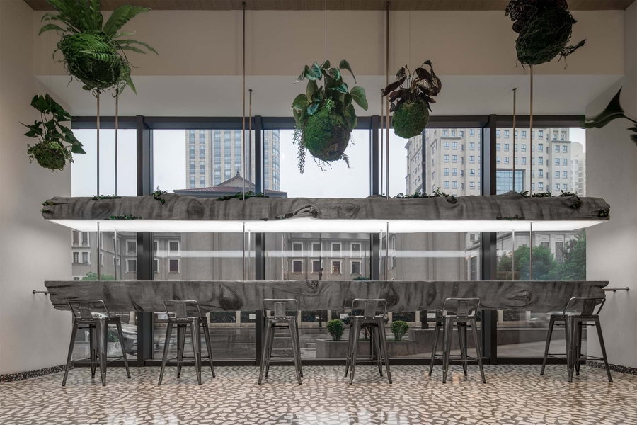 Suspended bisected log serves as another long table inside Shanghai's Metal Hands Coffee Shop. 