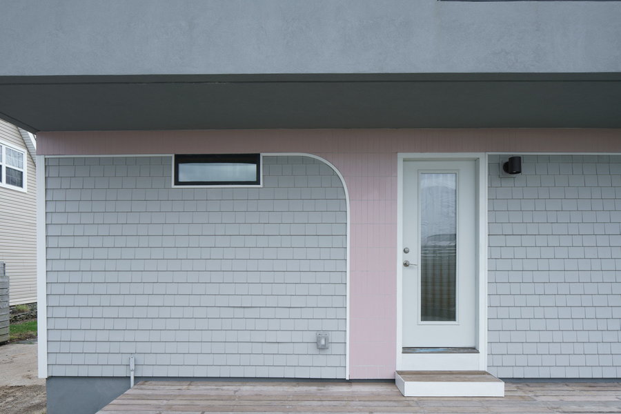 Soft pink tiles drag down from the House on House addition onto the facade of the original structure.