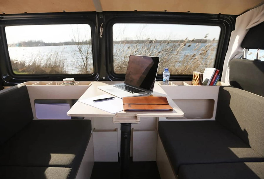 Fold-out table inside the Ventje campervan in use as a workspace.