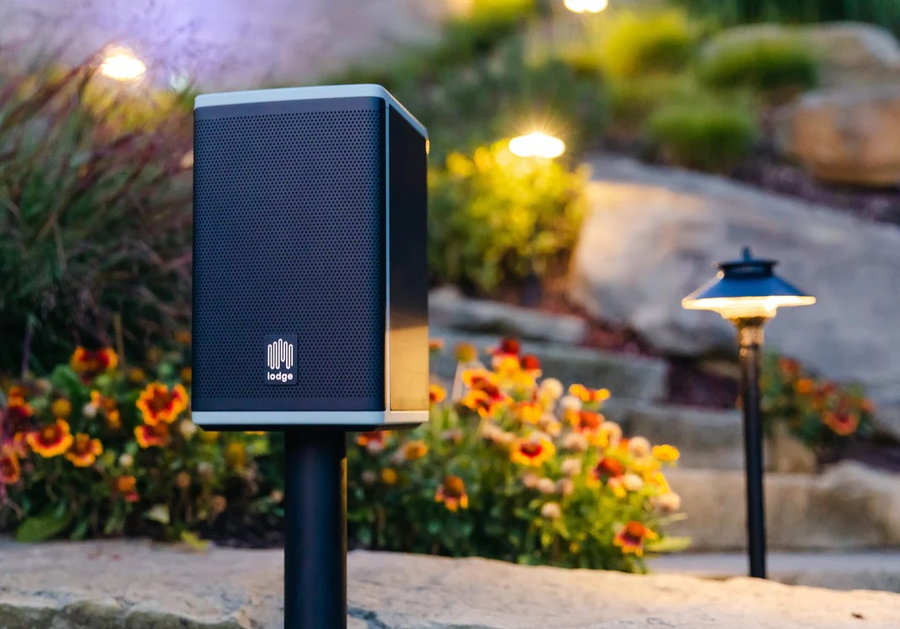 Lodge Solar Powered Speaker mounted in a tranquil outdoor space.