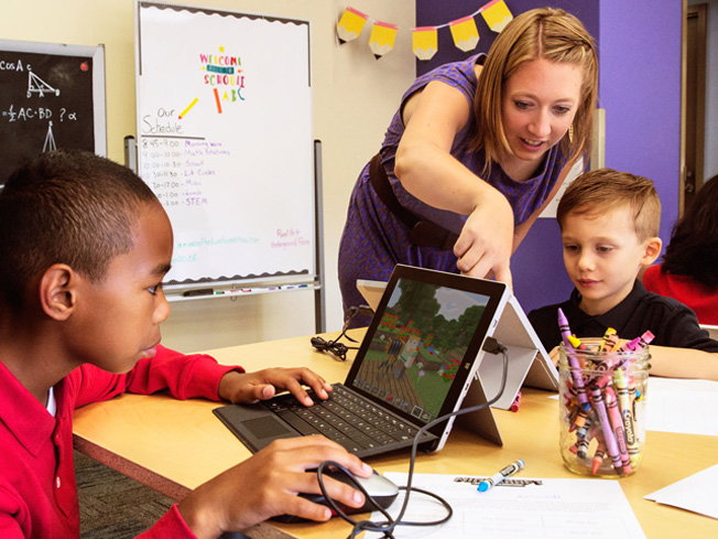 Kids enjoy learning via Minecraft, while a parent stands nearby willing to help them along.