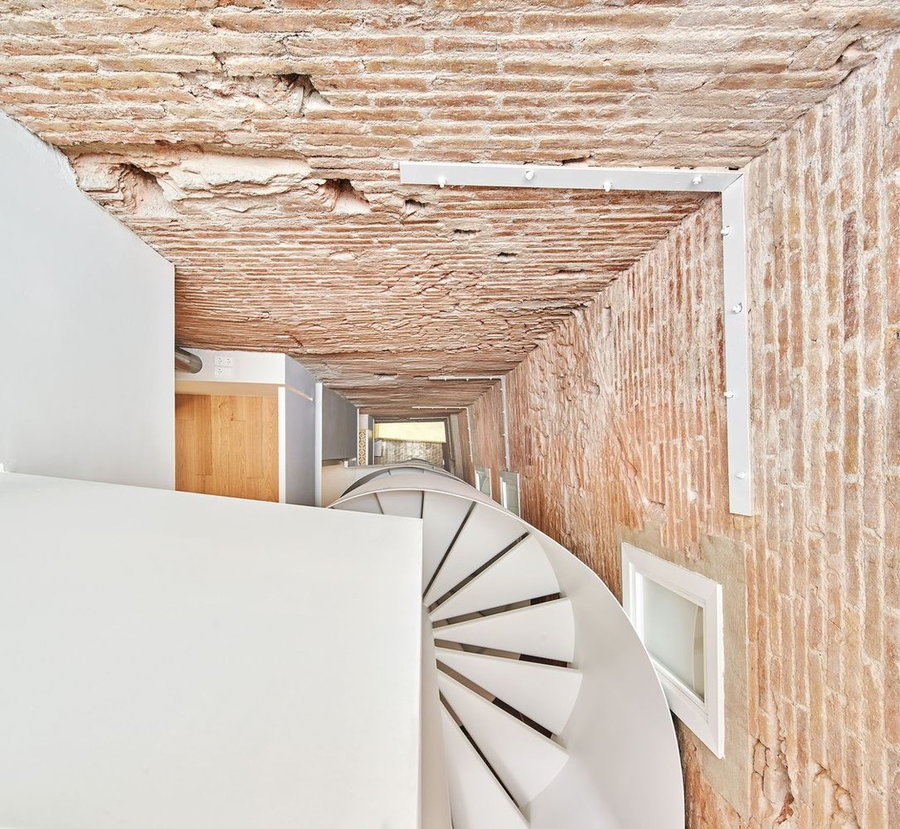 View down the central spiral staircase at the heart of the Raúl Sánchz-renovated BSP 20 apartment in Barcelona.