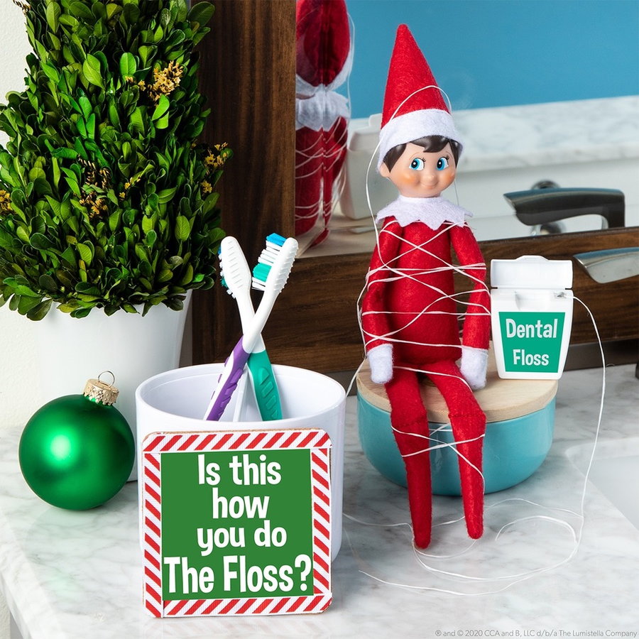 Elf on the Shelf tangled up in dental floss.