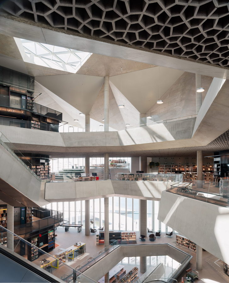 The main atrium of Oslo's new Deichman Bjørvika Public Library, complete with intricate honeycomb patterns etched into the ceiling. 