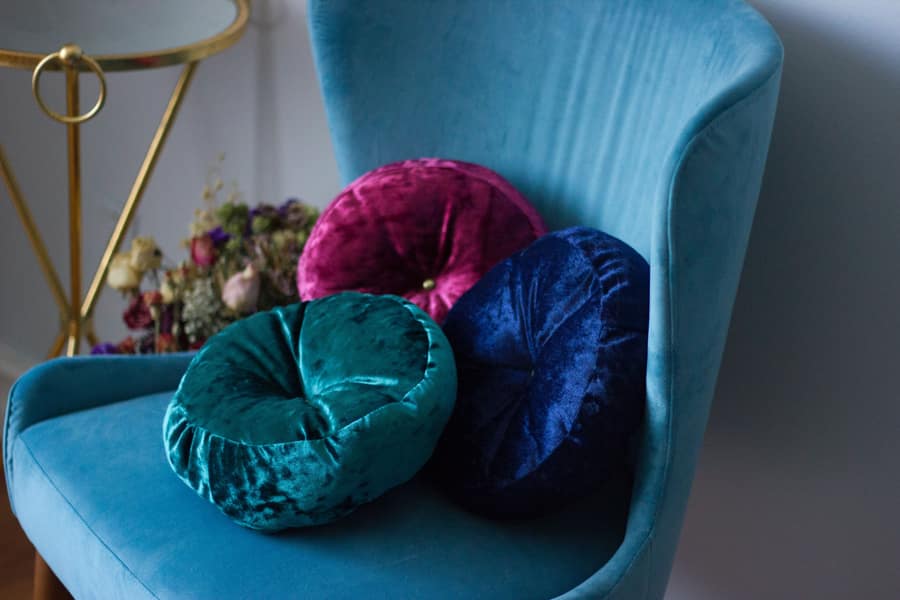 Crushed Velvet Throw Pillows atop a blue love seat