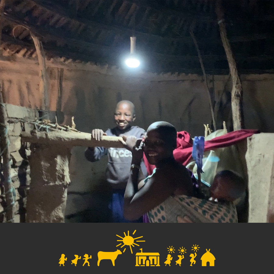 A rural African family lights up their home at night using the same battery charged by the Solar Cow.