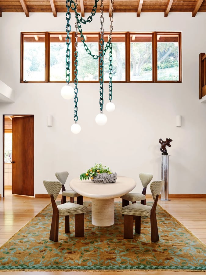 Sculptural chains and lighting orbs hover over the dining area in Chamberlain's LA home. 