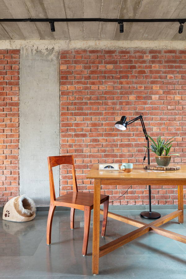 Simple table and chair setup in AKDA's Louis Khan-inspired brick apartment building in New Delhi.