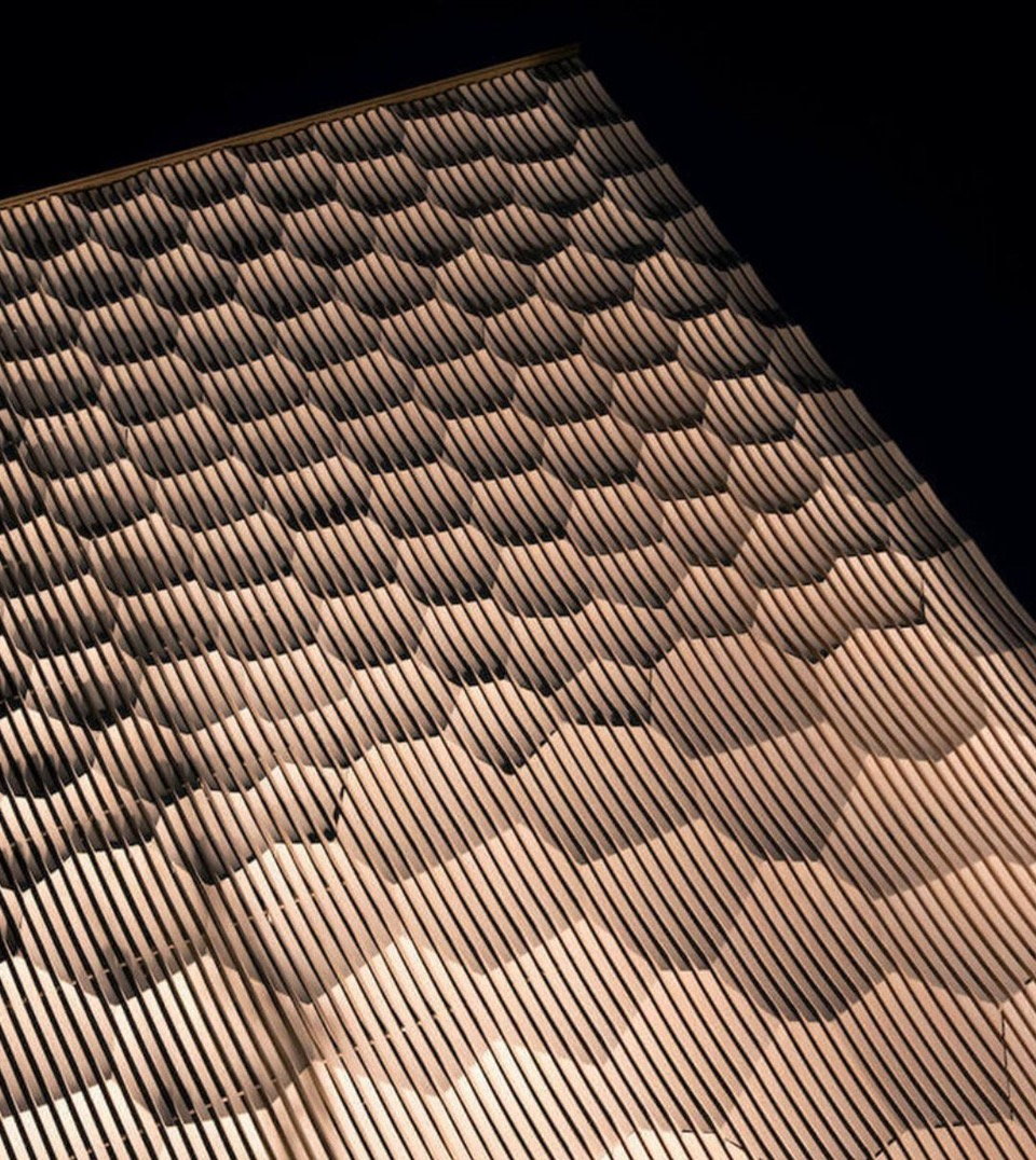 A closer look at the rippling patterns of Kengo Kuma's wood facade for the British Antique Museum in Kamakura, inspired by the traditional Japanese craft of Kamakura-bori. 