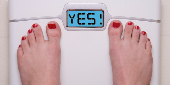 Top view of feet on weighing scale. Women weigh on a weight