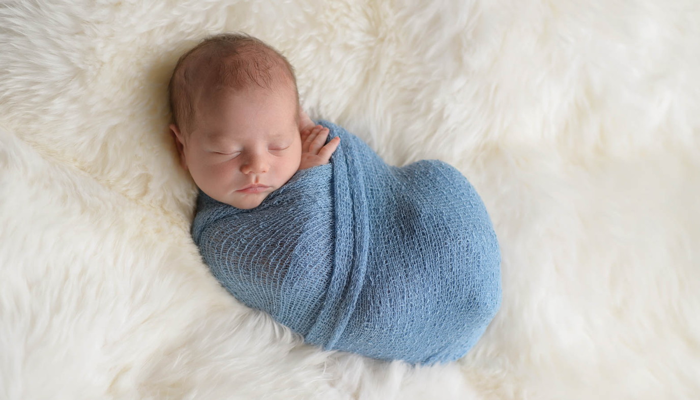baby swaddled in blue blanket