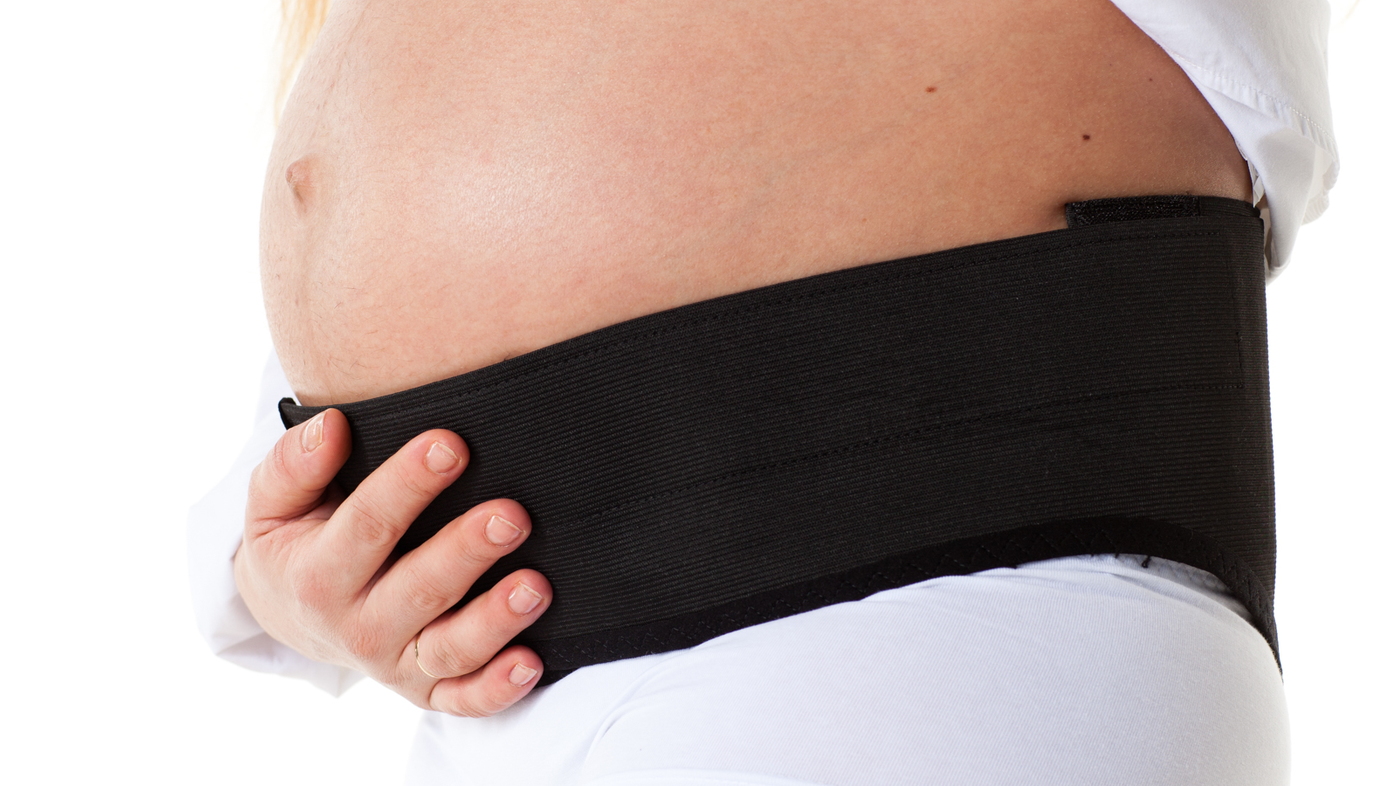 pregnant woman wearing back support brace