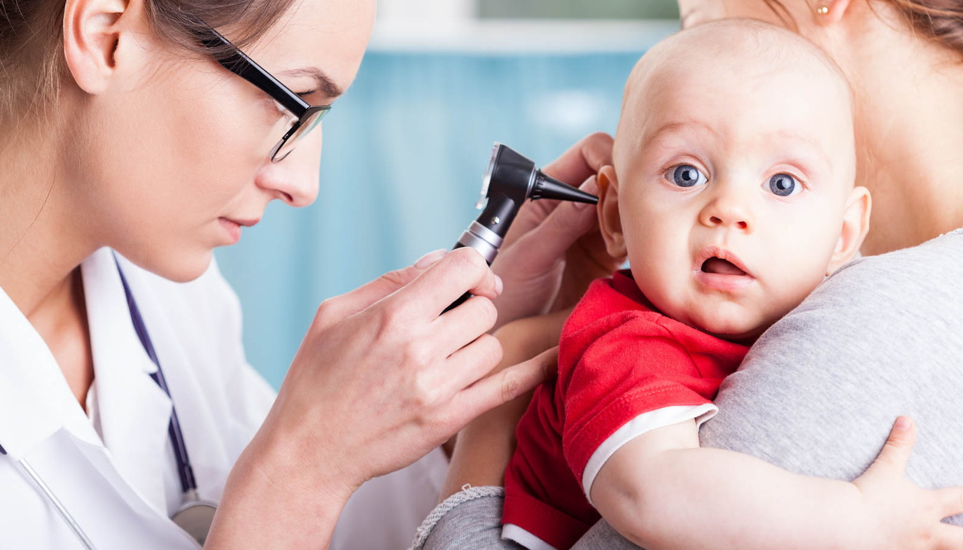 doctor looking inside baby's ear with an otoscope