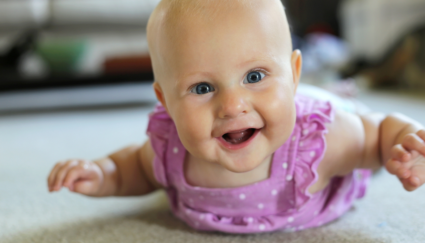 smiling baby doing tummy time
