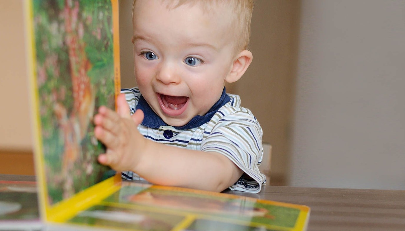 baby playing with book