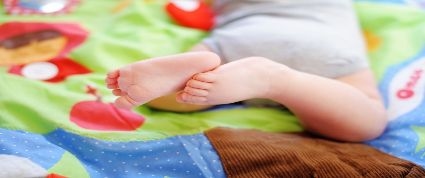 Baby feet on a blanket.