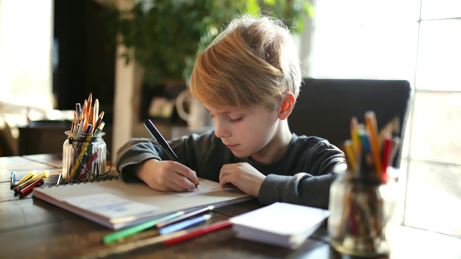 boy writing at desk