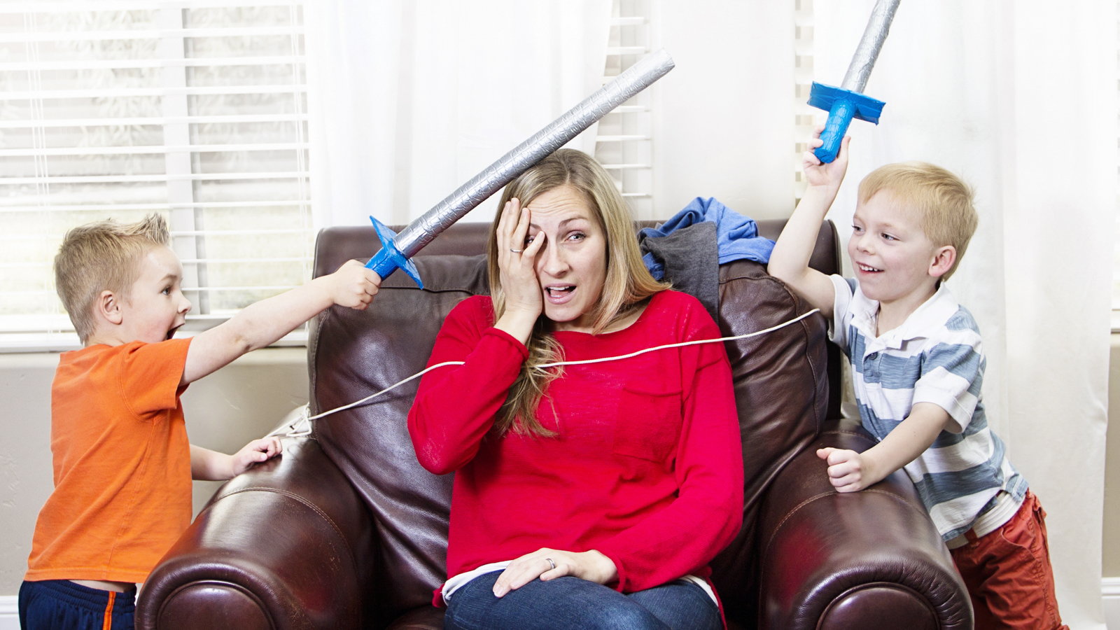 boys playing sword fighting with mom in the middle