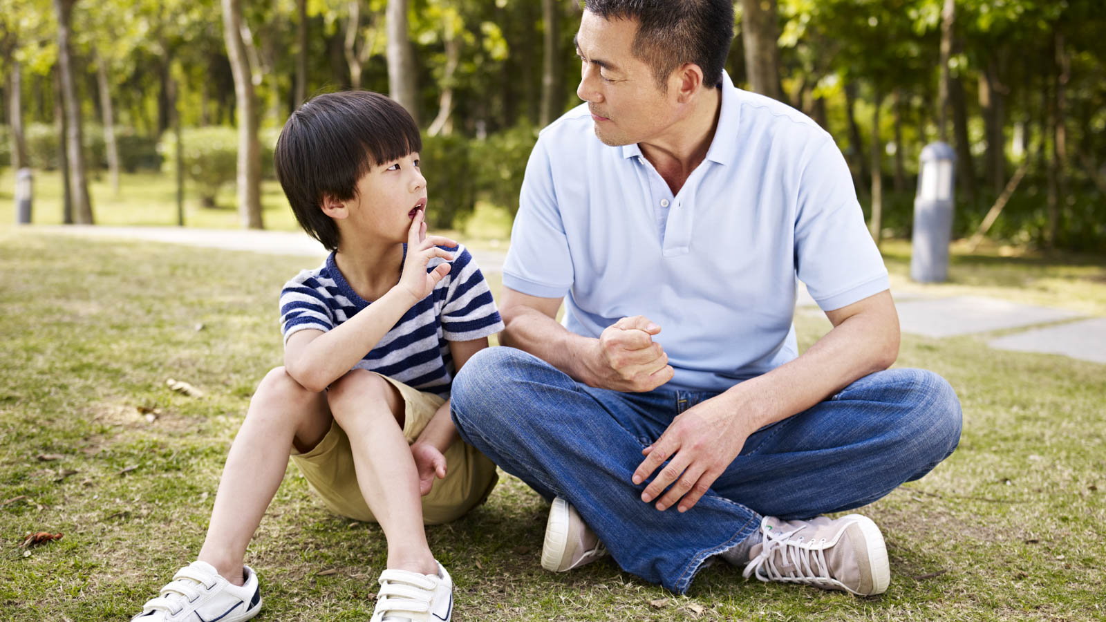 father talking to son at the park