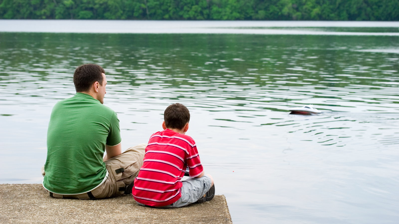 dad and son sitting at the lake