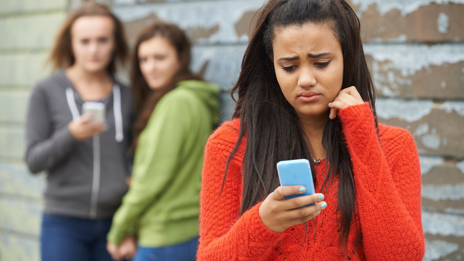 sad teen looking at smartphone