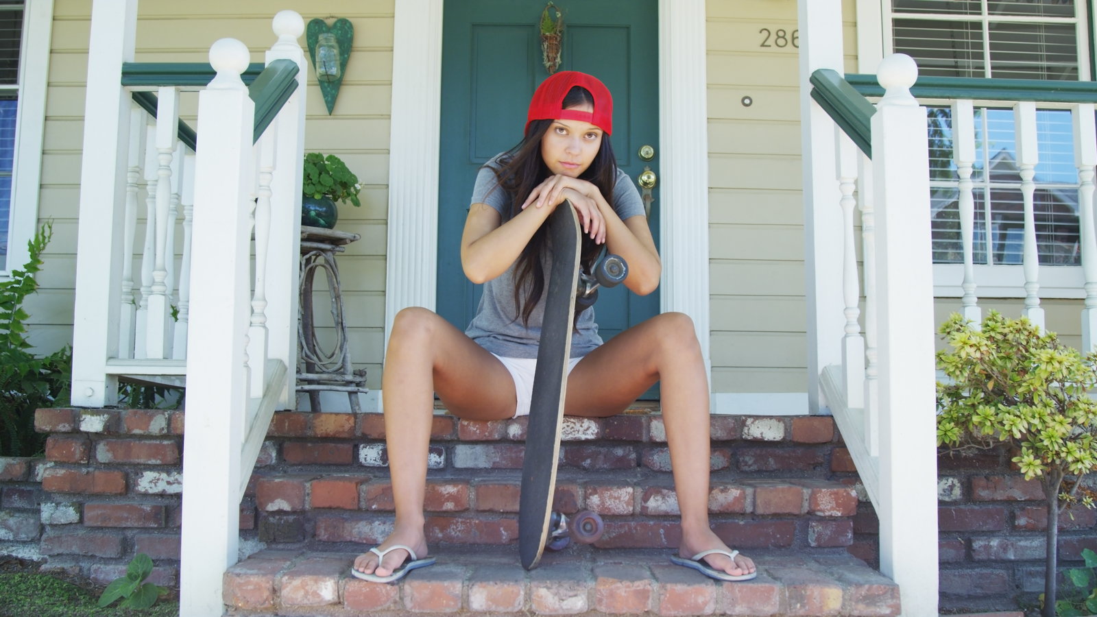 depressed teenage girl holding skateboard