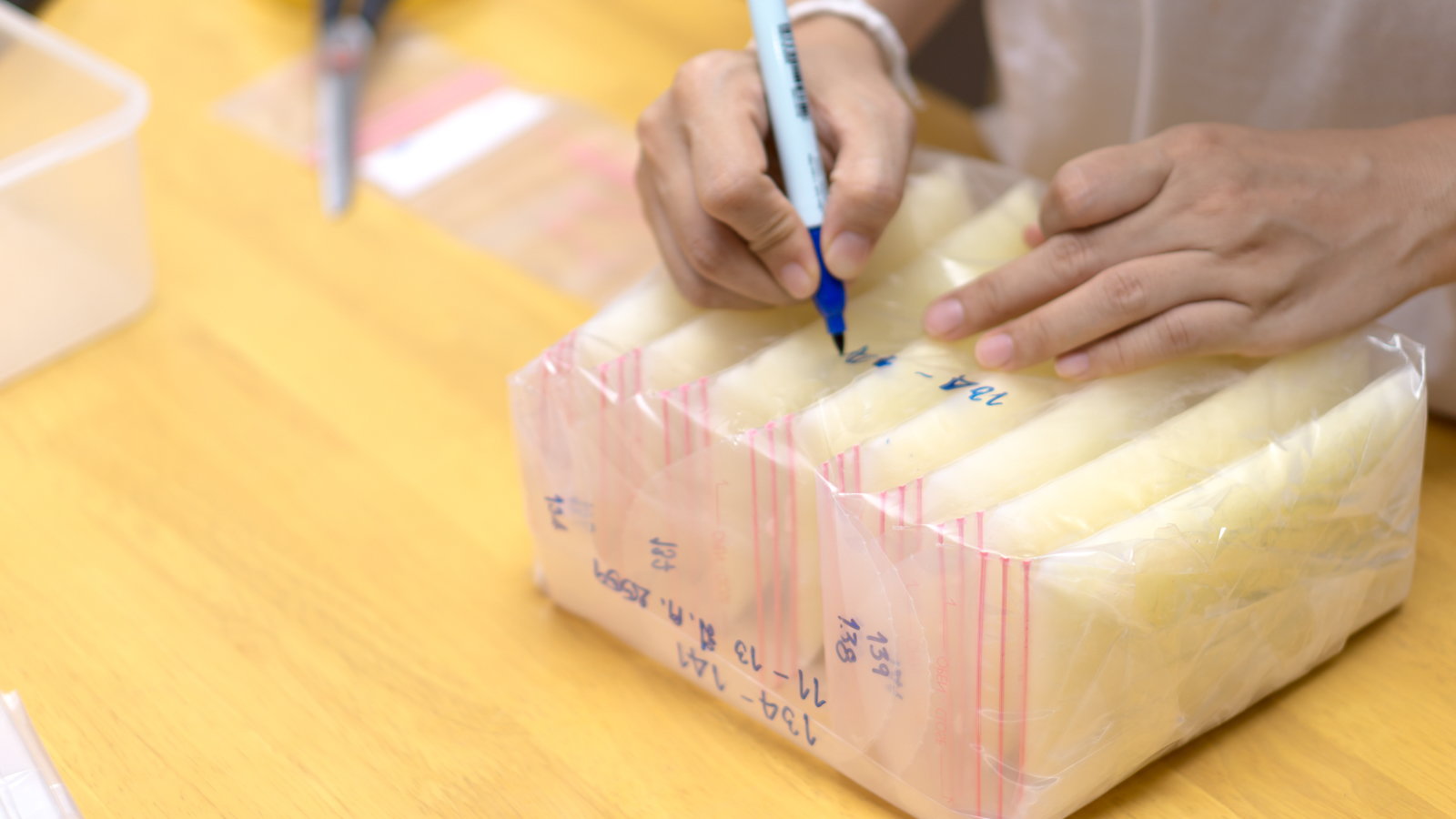 woman writing dates on breast milk