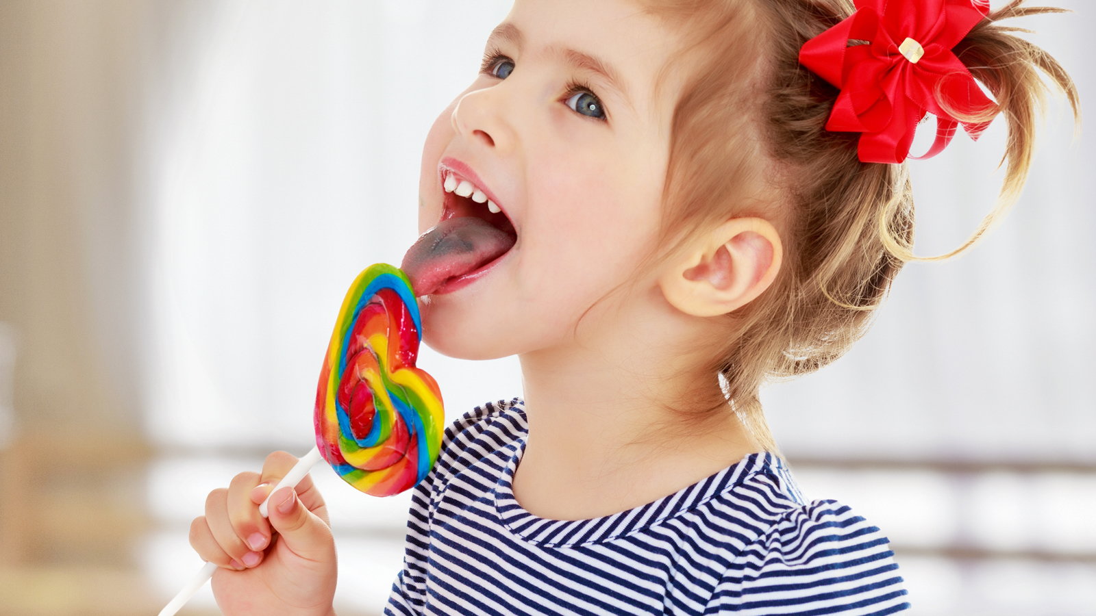 child licking lollypop
