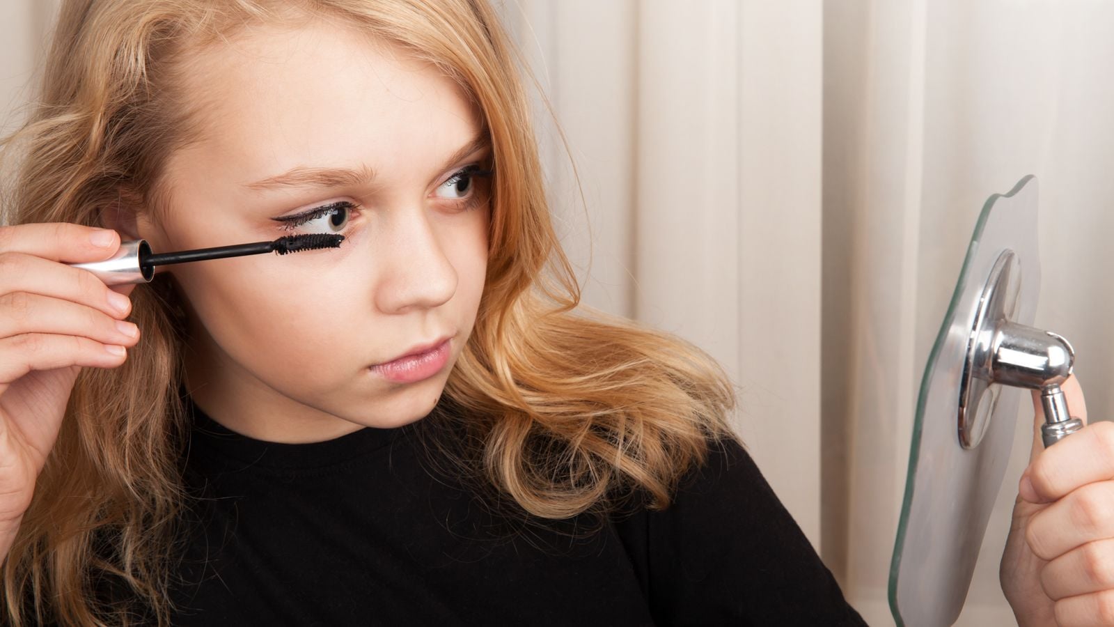 teen putting on mascara
