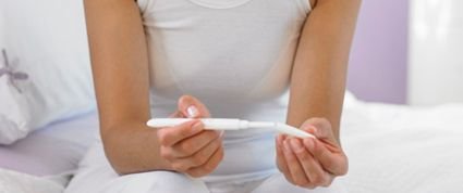 woman reading pregnancy test
