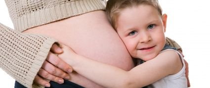 boy hugs pregnant mother's belly