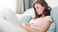 woman on the couch with stomach pain