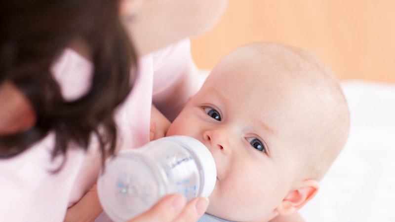 Parent bottle feeding baby