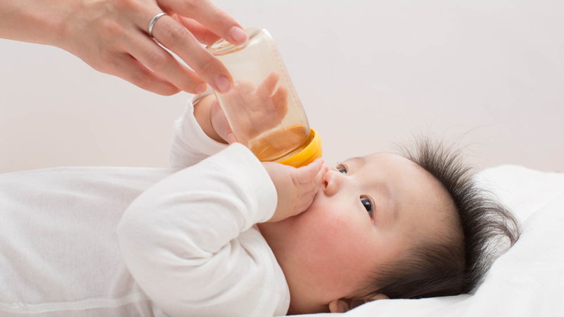 baby drinking out of a bottle