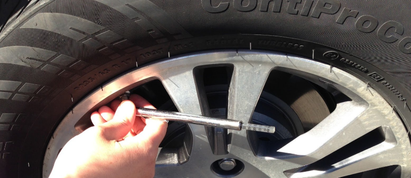 Checking tire pressure using pressure gauge