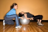 Woman exercises with physical therapist despite pain
