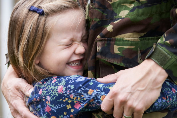 military personnel hugging their child