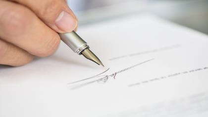 A hand signing an important document. 