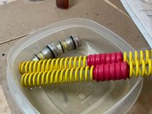 Springs and preload adjuster caps in a tub full of water that came out of the fork